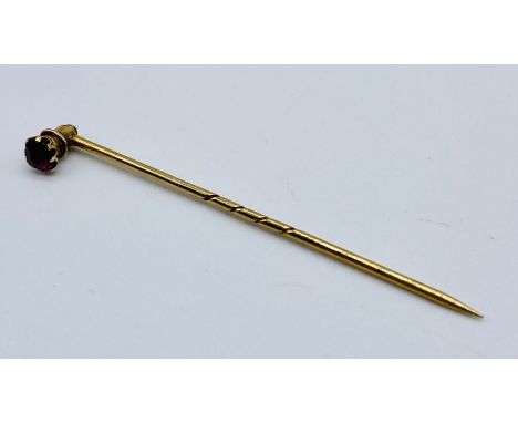 A 15ct gold (tested) stick pin set with a ruby, the top section unscrews