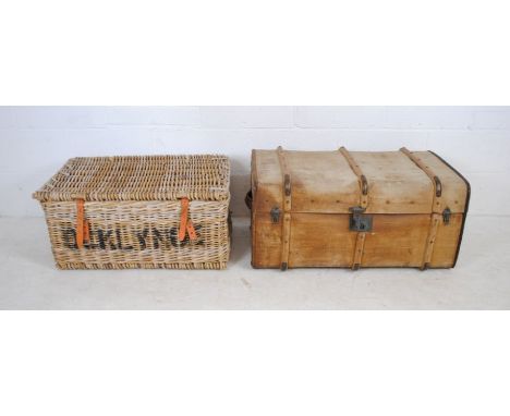 A vintage wicker laundry basket along with a cabin trunk