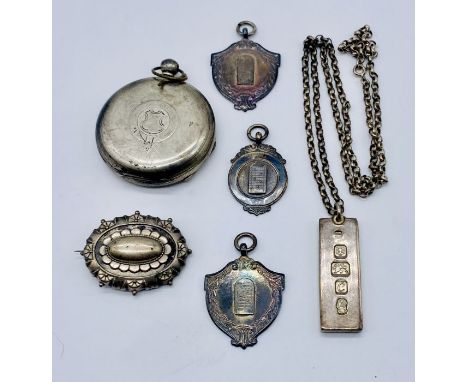 Three hallmarked silver shove ha'penny medallions, silver ingot on chain, Victorian brooch and silver watch case