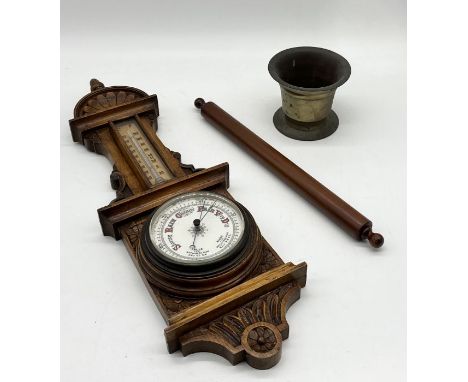 A carved wooden aneroid barometer along with a brass mortar etc.
