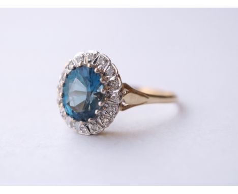 BLUE TOPAZ AND DIAMOND CLUSTER RING
the central oval cut blue topaz in diamond surround, on nine carat gold shank, ring size 