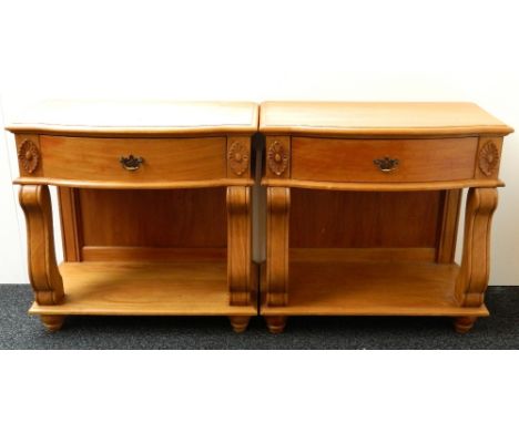 PAIR OF LIGHT MAHOGANY SERPENTINE BEDSIDE TABLES
with a frieze drawer flanked by flower head motifs, with scroll supports to 