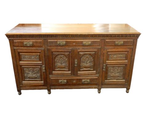 EDWARDIAN OAK SIDEBOARD
the carved frieze above three drawers with a pair of central cupboard doors and drawer below, flanked