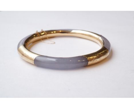 FOURTEEN CARAT GOLD MOUNTED POLISHED HARDSTONE BANGLE
the mounts with engraved decoration, 7cm diameter