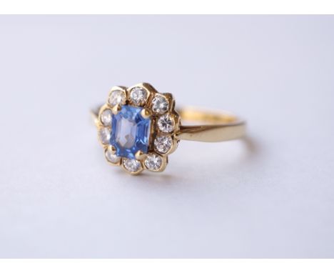 PRETTY SAPPHIRE AND DIAMOND CLUSTER RING
the central emerald cut sapphire in ten diamond surround, on eighteen carat gold sha