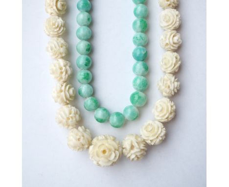 GRADUATED CARVED IVORY BEAD NECKLACE
with screw clasp, approximately 90cm long; and a jade coloured hardstone bead necklace, 