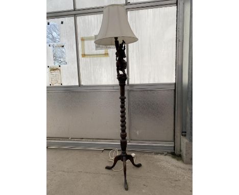 AN EARLY 20TH CENTURY OAK TRIPOD LAMP WITH BARLEYTWIST COLUMN, WITH CARVED HARDWOOD ORIENTAL FIGURE ON THE TOP, COMPLETE WITH