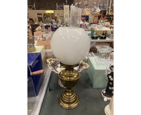 A VINTAGE BRASS OIL LAMP WITH CLEAR GLASS CHIMNEY AND OPAQUE ROUND SHADE HEIGHT APPROX 50CM 