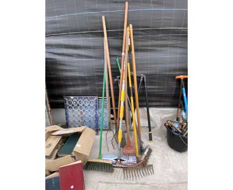 AN ASSORTMENT OF GARDEN TOOLS TO INCLUDE SPADES, RAKES AND BRUSHES ETC 