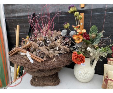 A CERAMIC JUG AND A WICKER BASKET CONTAINING ARTIFICIAL FLOWERS 