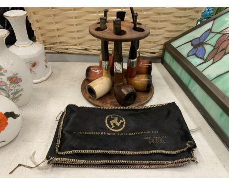 A WOODEN PIPE STAND CONTAINING SIX PIPES - TWO WITH SILVER COLLARS - PLUS FOUR LAXEY PIPES BLOCK MEERSCHAUM BAGS 