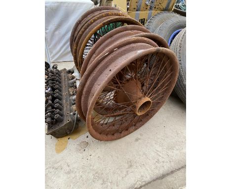 FOUR VINTAGE WHEEL RIMS AND AN ENGINE PART 
