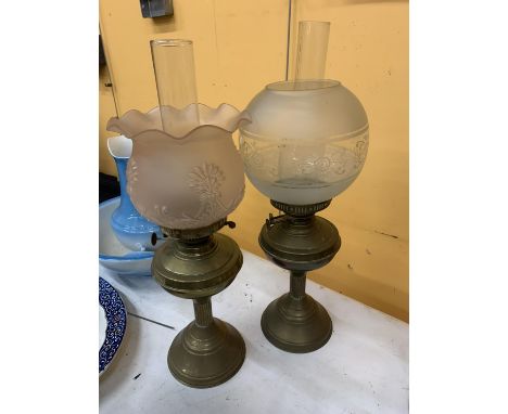 TWO VINTAGE OIL LAMPS WITH BRASS BASES, ONE WITH A PALE PINK FLUTED EMBOSSED GLASS SHADE, THE OTHER A FROSTED GLASS WITH ETCH