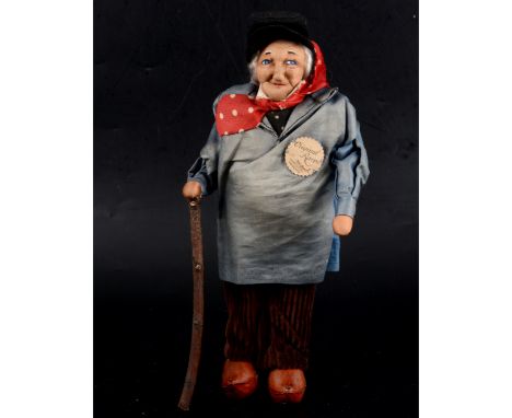 A French Ravca Normand stockinette doll, elderly man, with stick, original label, 26cm.