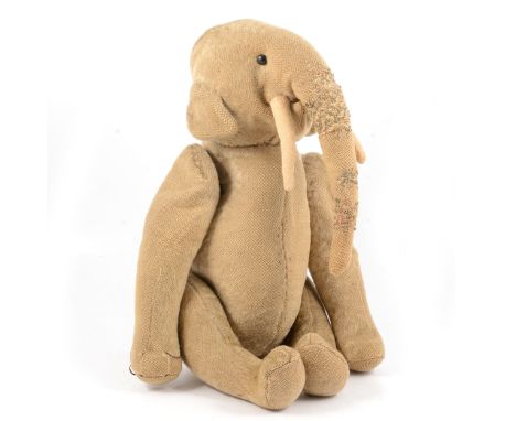 An early 20th century toy straw filled elephant, possibly by Steiff, with small black button eyes, jointed limbs with metal p