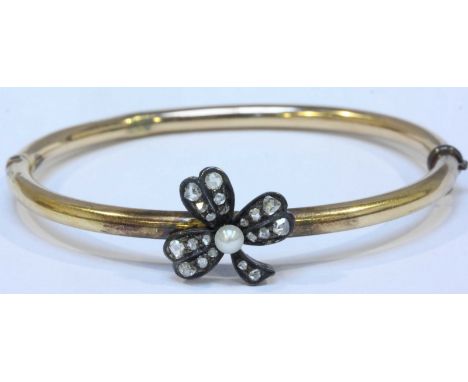 A 19th century yellow metal and diamond hinged bangle, the bangle mounted with a silver three-leaf clover, the centre of whic