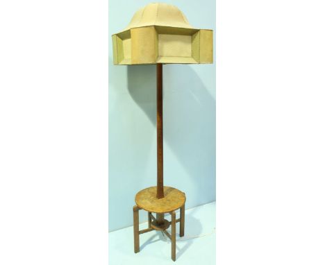 An Arts and Crafts oak standard lamp table with a stitched faux velum shade, tapered cylindrical to squared support and raise