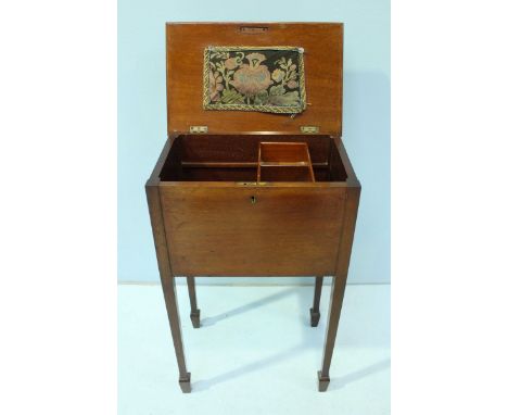 An Edwardian stained walnut sewing box/table, the hinged top opening to reveal a mounted, embroidered pin cushion and storage