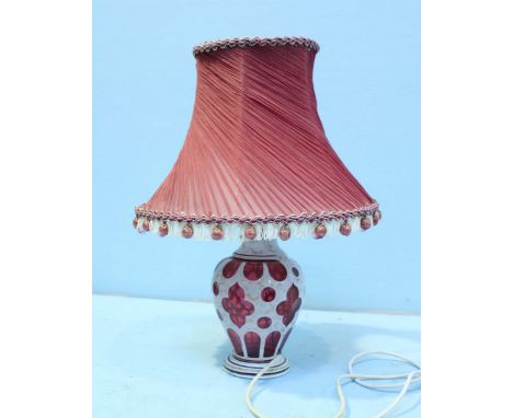 A 19th century overlaid, opaque ruby glass vase, converted to an electric lamp, the handmade salmon pink shade with frilled d