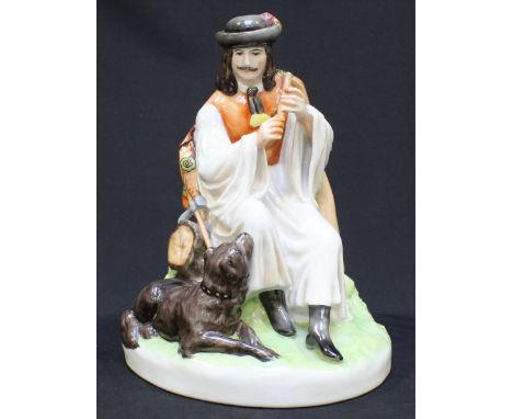 A Zsolnay pottery figure group of a seated man playing a flute next to a dog, 23cm high