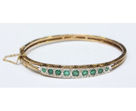 A 9ct gold antique style emerald and diamond bangle, approximate weight 17.9grms.