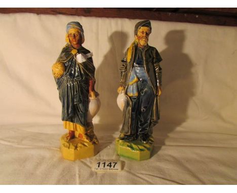 A pair of ceramic figures of Arabian merchants