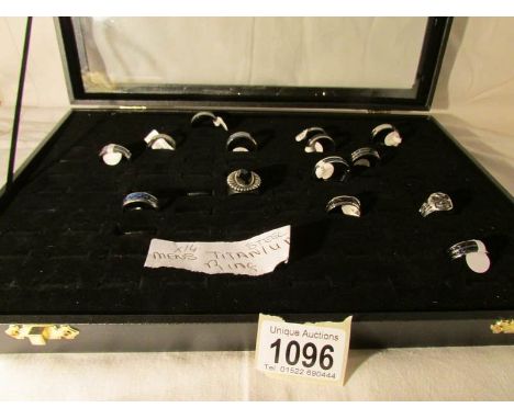 A display case containing 14 men's titanium rings