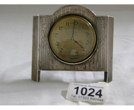 A small dressing table clock in silver frame (clock needs attention)