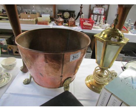 A copper pot and a brass lantern style table lamp