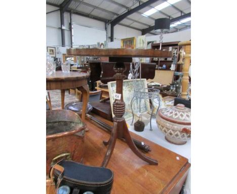 An oval tripod wine table with leather top