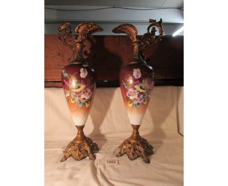 A pair of Victorian ceramic bodied ewers with metal bases and tops hand painted with bird scenes
