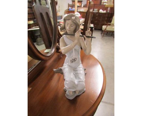 A Lladro porcelain figurine of a girl playing flute entitled 'Graceful Tune', marked 65781 flower on back of head is missing 