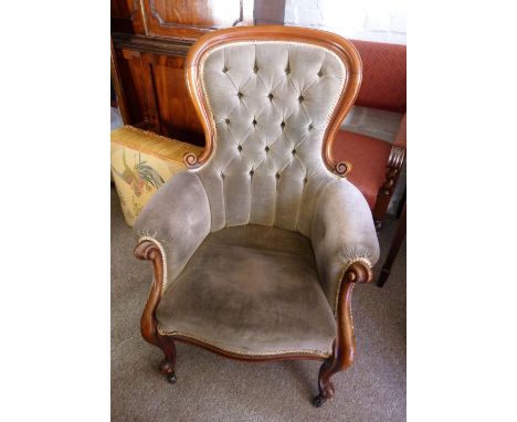 A Victorian Mahogany Drawing Room Armchair, the carved and button upholstered back above a padded seat with scroll arms and c
