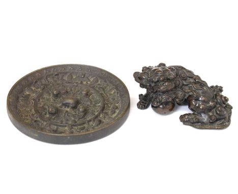 Chinese cast bronze hand mirror, 11.5cm diameter, and cast Dog of Fo paperweight, 9cm wide, (2)