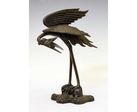 Japanese bronze figure of a crane, Meiji period, modelled with a fish tail in its beak, a turtle to the naturalistic base, in