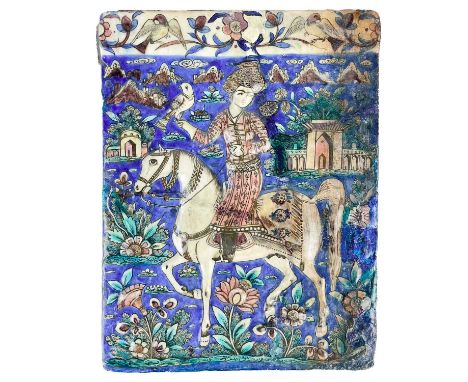 A large Persian pottery tile, Qajar Dynasty. Depicting a man on horseback, with a hawk perched on his right hand, on a foliat