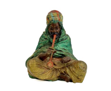 A cold painted bronze model of a seated Arab smoking a pipe. Height 8.5cm, width 6.5cm, depth 5.5cm.