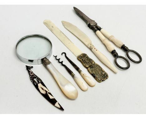 A collection of Late 19th and Early 20th Century bone and mother of pearl. Utensils, vanity tools, magnifying glass etc. 