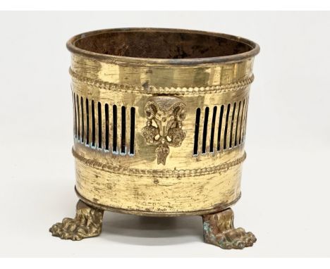 A vintage Georgian style pierced brass jardiniere/planter with lion paw feet and rams head masks. 23x23x20.5cm 