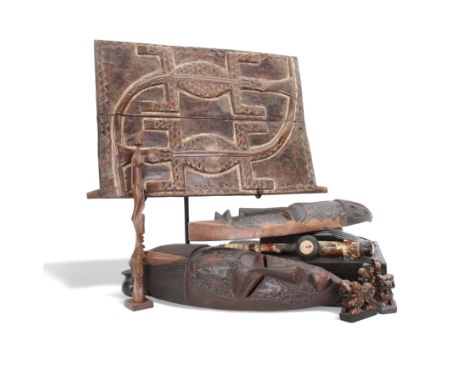 Carved African plaque, carved in relief with crocodiles, upon a metal stand, together with two carved masks, bone opium pipe 