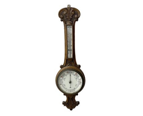 Edwardian - carved oak aneroid barometer, with a rounded top carved with scroll work, 8"porcelain dial with weather predictio