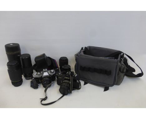 A Canon EF camera and three lenses, also a Minolta camera and extra cased lenses.