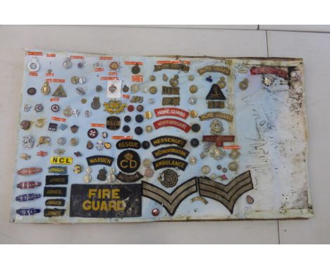 An interesting board of badges including G.P.O., ambulance, home guard, war service, St. Johns, British Rail, police, dischar