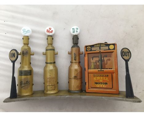 A set of Tipp & Co. tinplate petrol pumps, three pumps with glass globes for Pratts, Shell and BP, on a curved tin base with 