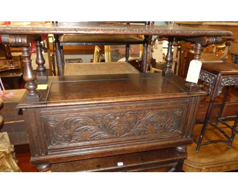 A circa 1900 floral relief carved oak monks bench, the fold-over top over typical hinged box seat base, width 107cm