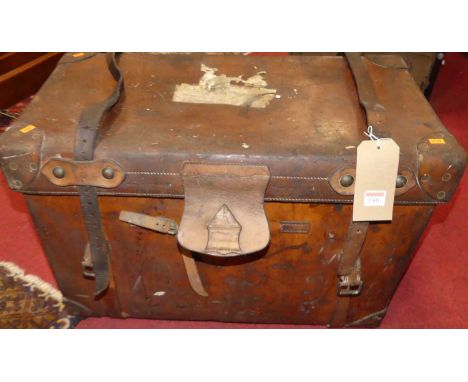 An early 20th century tan leather travelling trunk, the hinged cover with end carry handles and initialled A.M.B., width 72cm