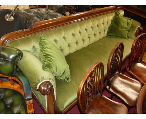 A mid-Victorian mahogany show frame scroll end sofa, green dralon button upholstered, the frame with floral carved detail and