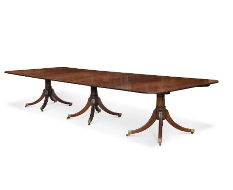 A George III style mahogany dining table, 20th century,the three pedestals on four downsplayed legs, caps and casters, with t