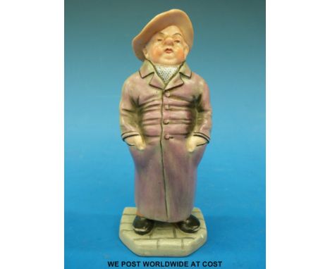 A Royal Worcester figure of a man in long coat and hat (14cm tall) 