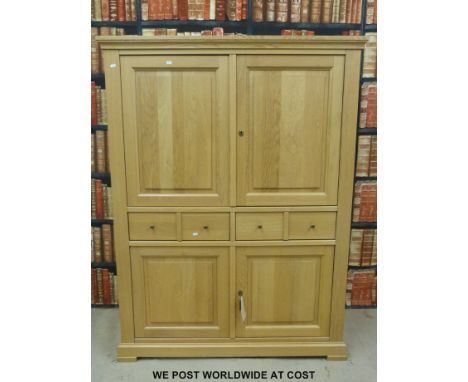 A modern light oak cupboard with two drawers and four doors (W131 x D50 x H172cm)